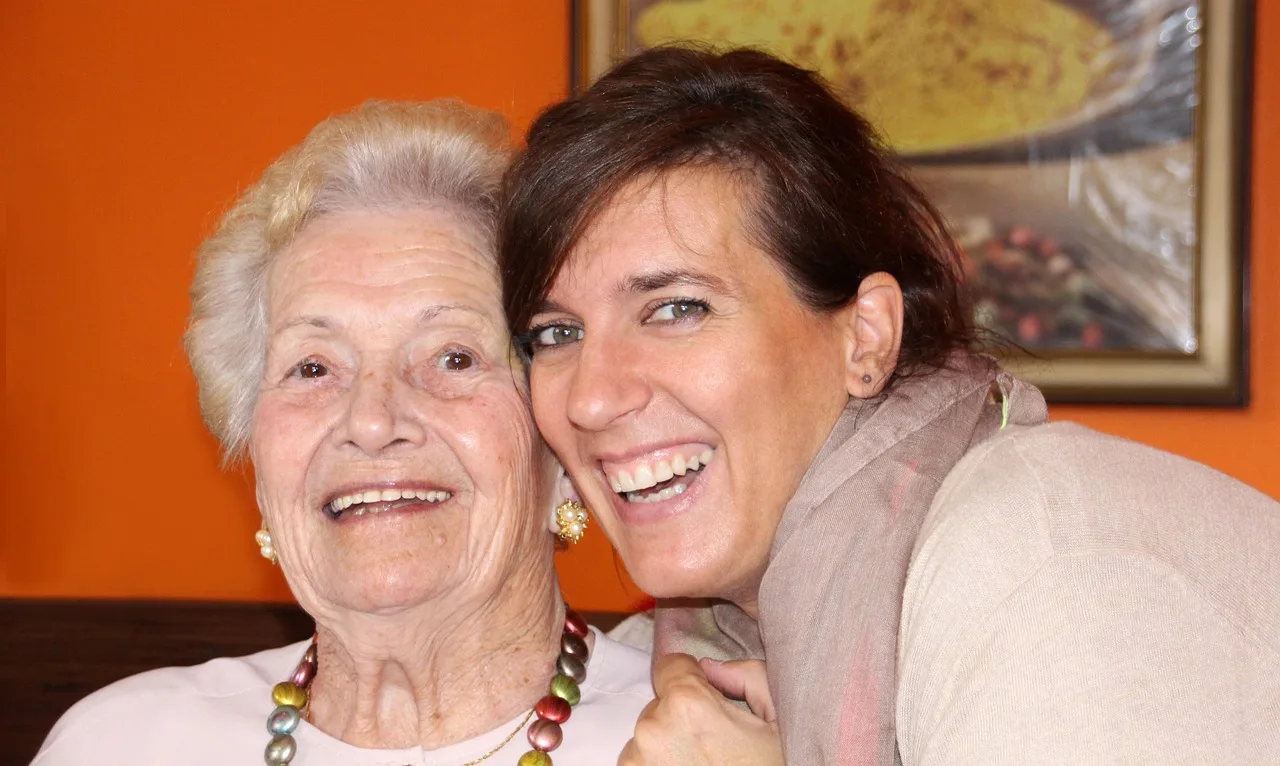 Donna anziana assistita in casa da un caregiver, simbolo del bonus di 850 euro per over 80 a febbraio.