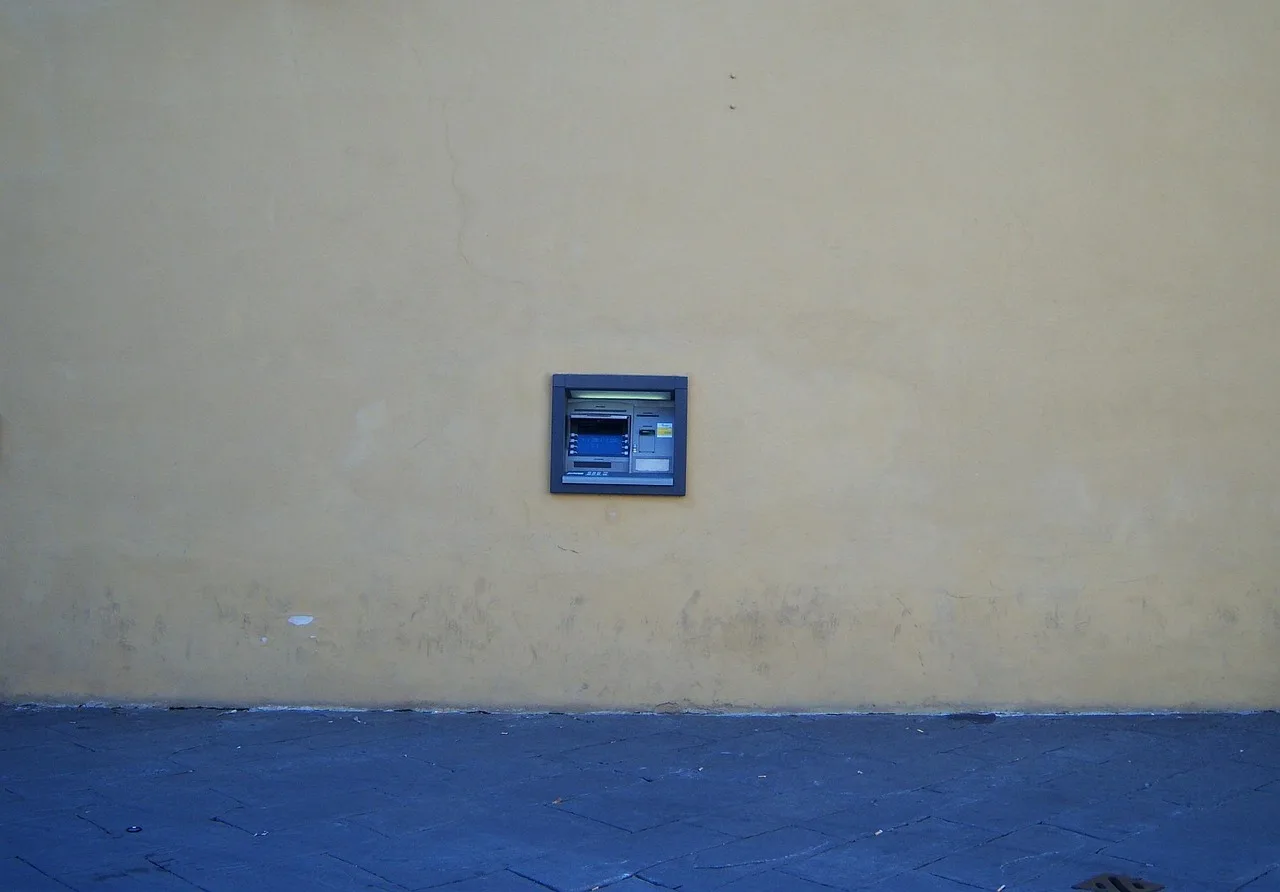 Immagine di un bancomat con un cartello che avvisa della nuova commissione di 2 euro dal febbraio 2024.